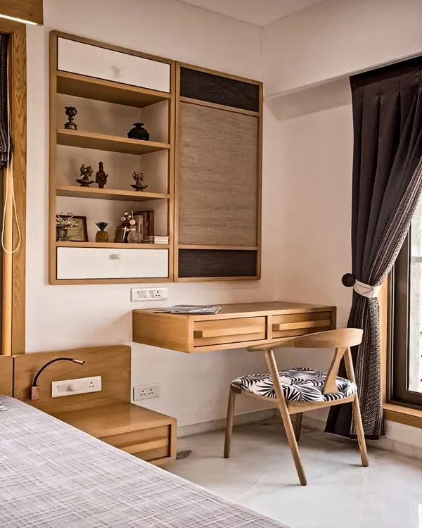 A sleek, wall-mounted study unit in a bedroom. The floating desk keeps the floor clear, while the combination of open shelves and closed cabinets provides versatile storage.
