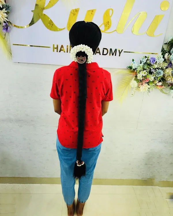 A classic South Indian bridal braid, showcasing a neat, extra-long style finished with traditional gajra and hair jewelry. We cover how to use hair extensions to achieve this dramatic length.