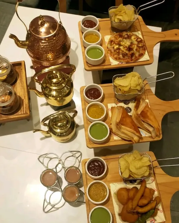 Our high-tea catering is perfect for afternoon gatherings. We offer a variety of snack platters featuring items like mini pizzas, pakoras, and puff pastries, served alongside different types of chai and dips.