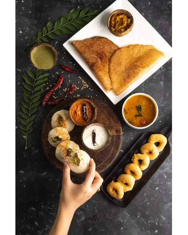 A complete South Indian breakfast spread, styled and shot for Double Tree by Hilton. This top-down flatlay captures the variety of the meal, from crispy dosas to savory sambar, perfect for a hotel menu.