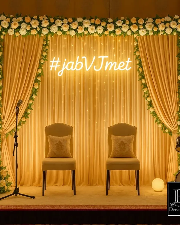 This elegant engagement stage is where forever begins. We combined soft golden drapes, a cascade of white and cream roses, and a custom neon hashtag sign to create a warm, romantic focal point for the happy couple.
