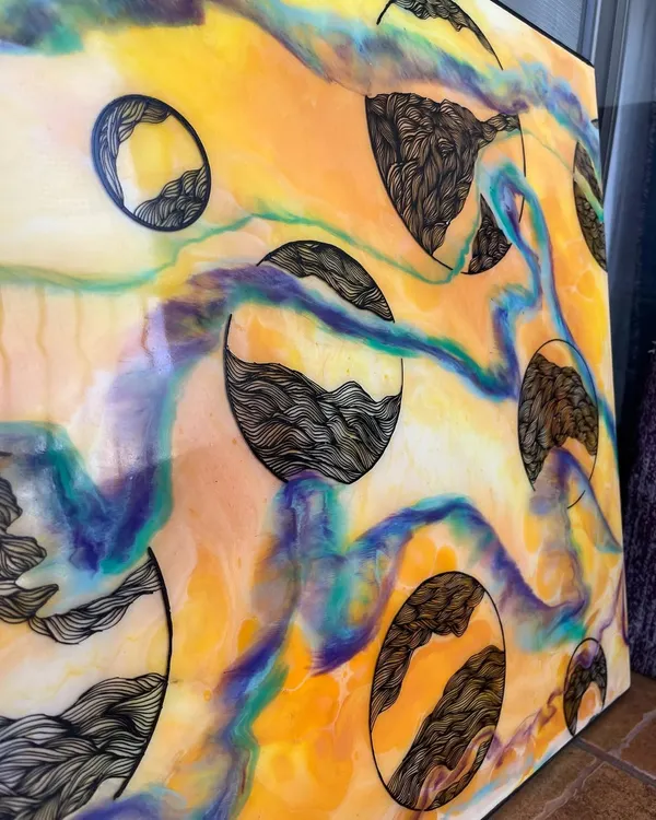 A closer look at my mixed-media work. The vibrant, fluid colors of the resin create a beautiful background for the detailed, hand-drawn doodle patterns inside each circle.