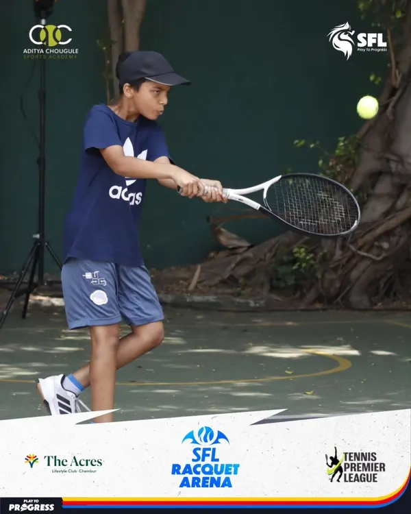 A young athlete demonstrates a powerful two-handed backhand during a competitive match, showing the technique and determination honed at our academy.
