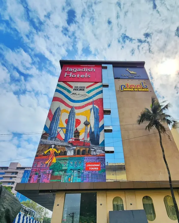 A stunning wide-angle shot of our 100-foot mural for Malaysia Tourism, covering the side of the Jagadish Hotel in Bengaluru.
