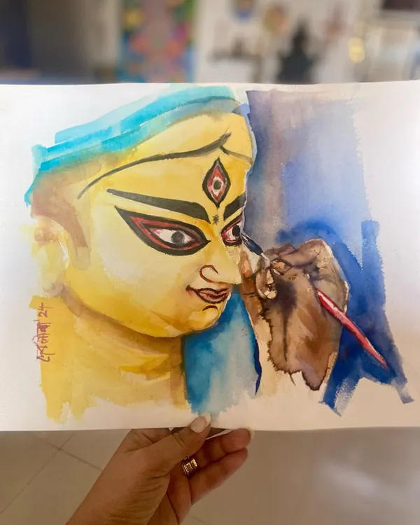A watercolor painting depicting "Chokkhu Daan," the sacred moment when the eyes are painted onto the idol of Ma Durga, signifying the beginning of her journey home for Durga Puja.