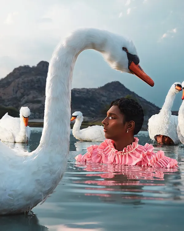 A surreal and serene composition from my 'KINNAR' series, exploring themes of grace and identity. This shoot blends high-fashion with fine art, styling a ruffled, vibrant garment to contrast with the natural tranquility of the water and swans.