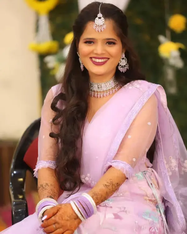 A stunning Sangeet look in a pastel lavender lehenga. The makeup is glamorous with a bold lip and sparkling diamond jewelry, perfect for a night of dancing.