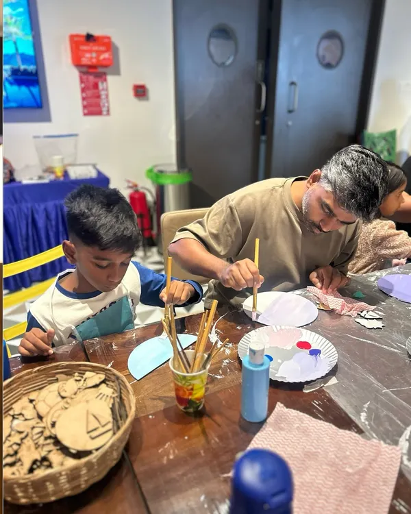 A father and son working together on a painting project during our Father's Day workshop. It's moments like these that make art so meaningful.