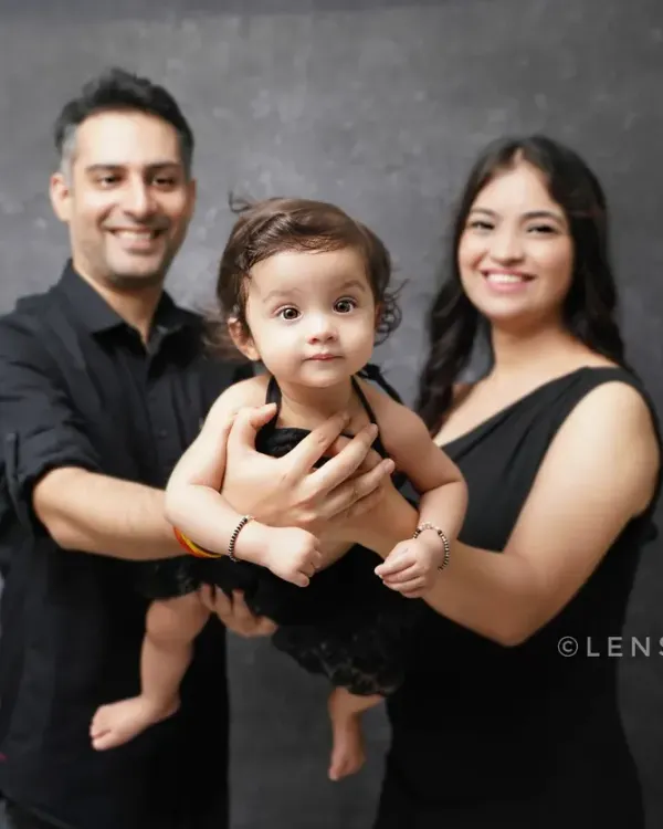 A classic and elegant family portrait. The coordinated black outfits create a timeless look against a simple studio backdrop, putting all the focus on your family's connection.