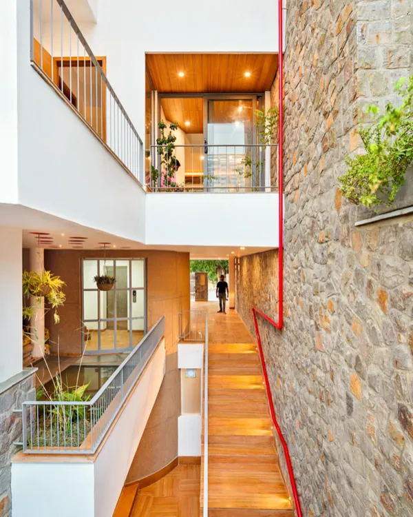 This is the People Tree House, a project that embodies my core belief in harmonious living. The design creates a multi-level experience, connecting interior spaces with a central water body and lush greenery, all while using a palette of natural stone and wood.