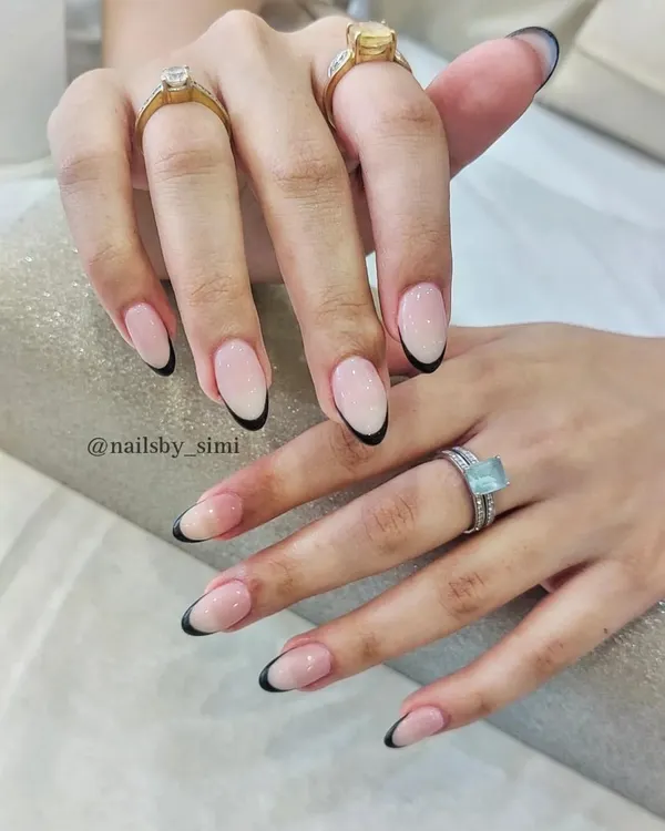 A modern classic. These deep curve black French tips on a natural nude base are so chic and sophisticated.