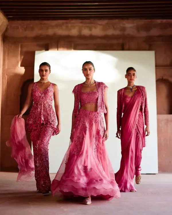 A full-length shot from a campaign showcasing three coordinated bridesmaid looks in shades of pink. The styling focuses on creating a harmonious group visual while allowing each outfit's unique details to shine.