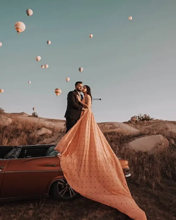 This is what dream pre-wedding photoshoots are made of. I love helping couples create moments like this, with my statement gown flowing against the magical backdrop of hot air balloons in Turkey. This peach polka-dot dress with its extra-long trail is perfect for a destination shoot.
