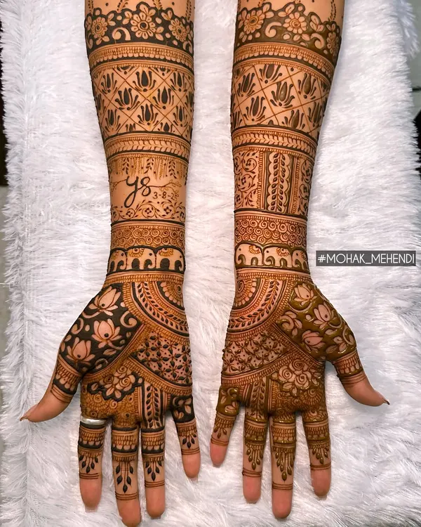 Happiness is handmade with henna. This full-arm bridal design combines traditional elements like elephants and lotuses with intricate geometric patterns for a stunning look.