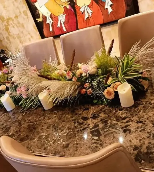 This modern centerpiece is perfect for a stylish dinner party. I used a mix of pampas grass, fresh flowers, and greenery, with several white pillar candles placed throughout the arrangement to create a warm and inviting look on the dining table.