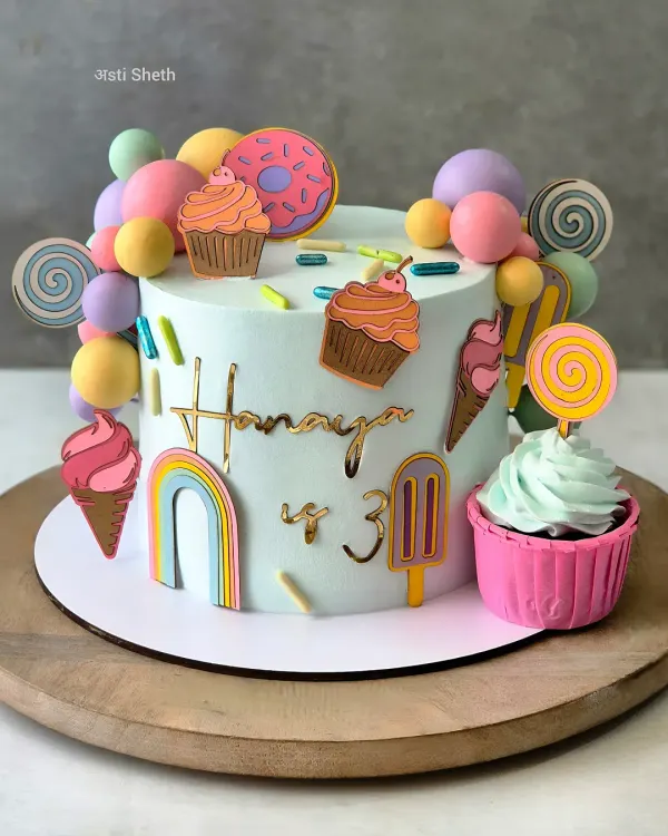 Welcome to Candyland! This 1.5kg Chocolate Mousse cake is a burst of colour, decorated with lollipops, donuts, and cupcakes to match the party's theme.