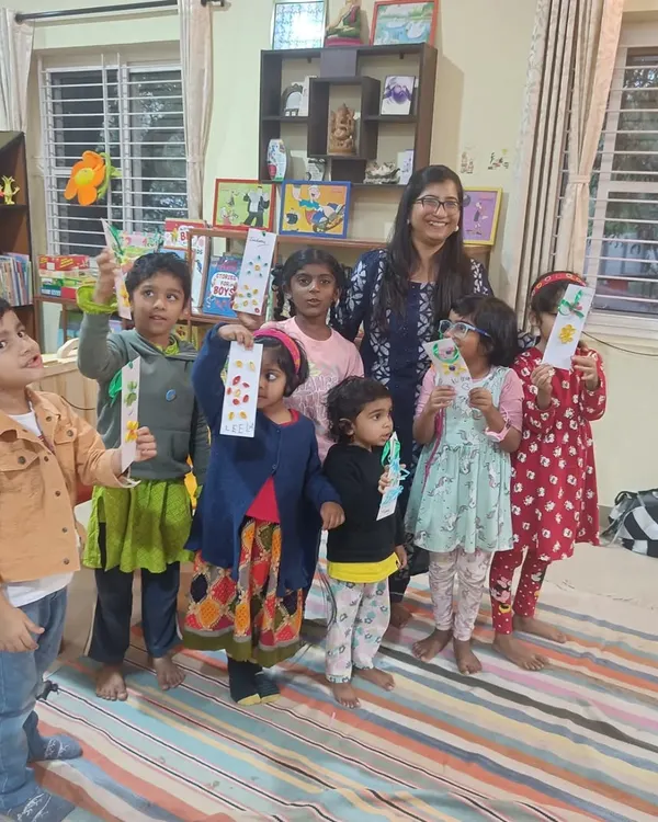 A proud moment. The storyteller poses with the children as they all hold up the beautiful bookmarks they created together.