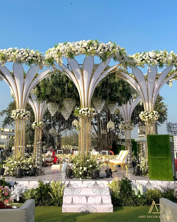 An architectural masterpiece, this grand white mandap features stylized floral pillars and a canopy of fresh white blooms, creating a modern yet timeless look for an outdoor wedding.