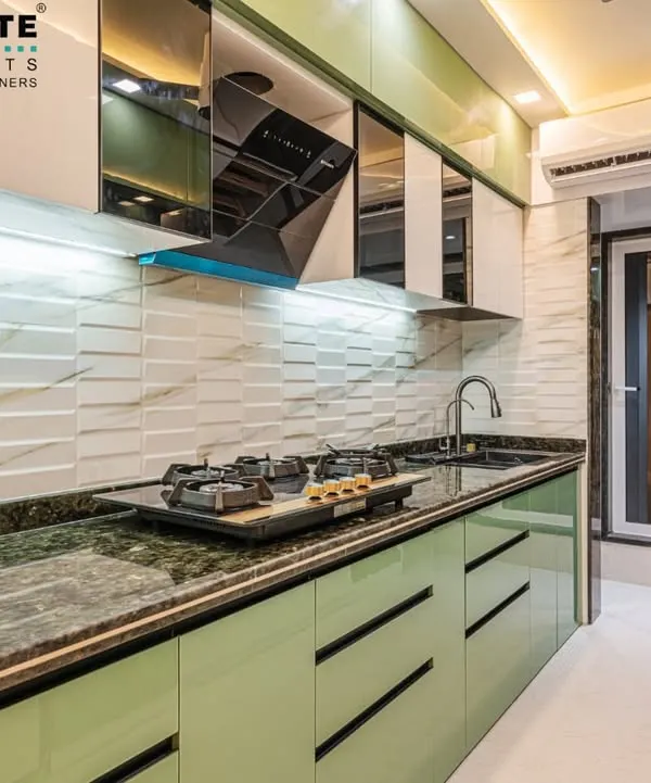 A modern kitchen in Seawoods featuring mint green handleless cabinets and a 3D textured white backsplash. The design includes a chimney hood and mirrored overhead cabinets, combining aesthetics with practicality.