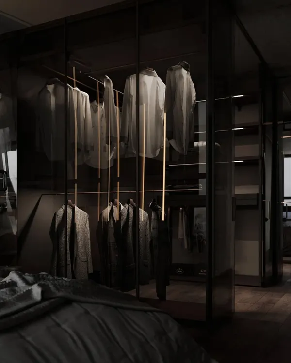 This view shows how a glass wardrobe can integrate seamlessly into a bedroom. The transparent doors and internal lighting make the clothing collection part of the room's decor, creating a sense of openness.