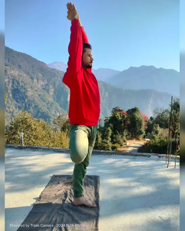 A side view of Vrikshasana, or Tree Pose, against a mountain backdrop. This posture is a beautiful expression of balance and grounding, which are key themes in my Hatha yoga sessions.