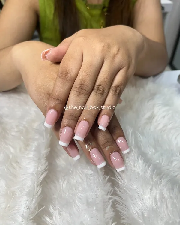 A beautifully executed classic French manicure on square-shaped extensions. The lines are clean, and the natural pink base gives it a very polished and sophisticated look.
