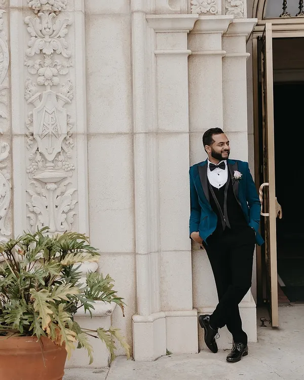 For the groom who wants to stand out, we styled this unconventional yet elegant teal tuxedo by Sarab Khanijou. It was the perfect, bold choice to complement his bride's ivory lehenga for their Catholic wedding.