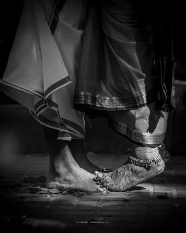 A symbolic black and white shot of the couple's feet during a ritual, representing their first steps together on a shared path.
