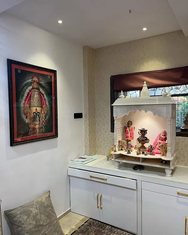 A beautiful home mandir I designed and installed. This piece combines a classic white marble temple with modern, high-gloss white cabinetry for storage, complete with elegant gold handles and dedicated overhead lighting to create a peaceful, sacred space.