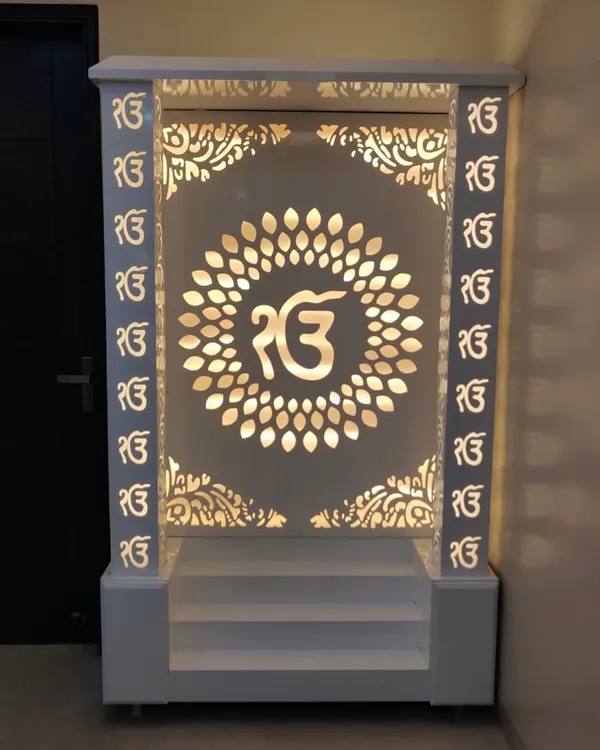 A beautifully crafted mandir we designed, finished in white with intricate 'Ek Onkar' jali work. The backlighting creates a serene and divine ambiance.