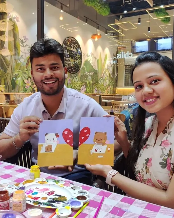 A couple proudly showing off the paintings they created together at our art date workshop. It’s a perfect way to connect and create a shared memory.