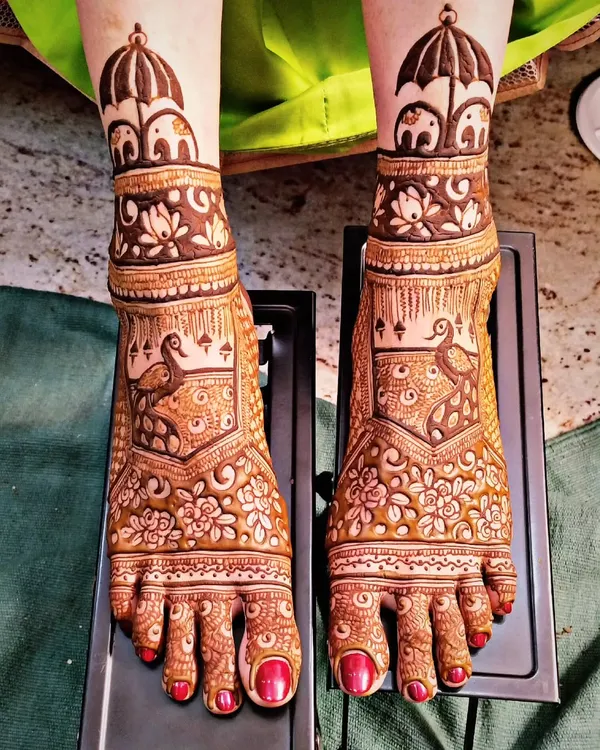 Bridal feet mehndi featuring majestic peacocks and cute little elephants. The design covers the entire foot, creating a look that is as intricate and beautiful as the mehndi on the hands.