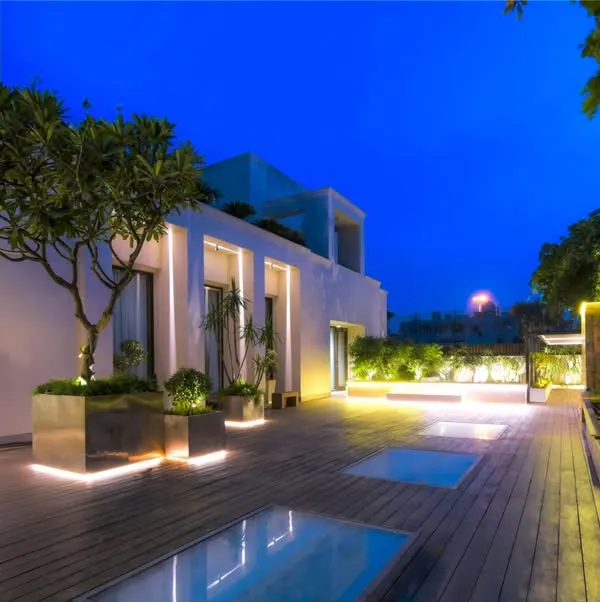 Our expertise lies in transforming urban terraces into sophisticated evening retreats. This project showcases strategic lighting design that highlights mature trees in sleek, modern planters and illuminates a spacious wooden deck, creating an atmosphere of serene luxury against the twilight sky.