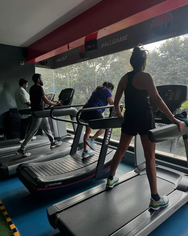 A view of the cardio section with several members on the treadmills. The atmosphere is focused and energetic.