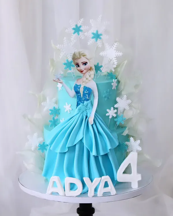 Let it go with this magical "Frozen" themed cake for a fourth birthday. This design features a beautiful Elsa figure in her iconic blue dress, surrounded by delicate, edible snowflakes and ice shards.