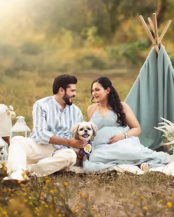 The whole family is excited, including the furry members! This outdoor picnic scene with their beloved dog is a perfect example of a fun, relaxed, and inclusive maternity session.