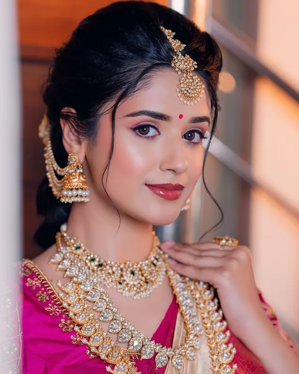 This is the look that captures the heart of South Indian tradition. I focused on creating luminous skin that glows, paired with classic eye makeup and a lip color that enhances her natural beauty, ensuring she looks timeless for her muhurtham.