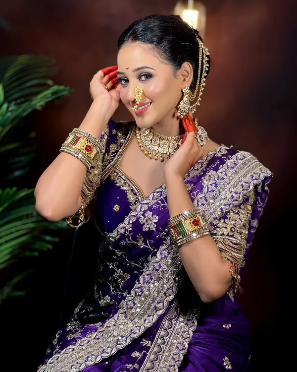 A flawless Maharashtrian bride. This look features a classic updo, a beautiful Paithani saree, and makeup that highlights her features, including the traditional nath and bindi.