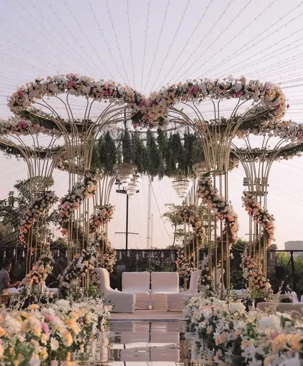 A fairytale mandap designed with heart-shaped floral arches in soft pastels, creating a truly romantic and grand centerpiece for an outdoor wedding.