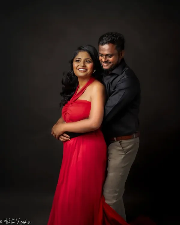 Together is a wonderful place to be. This couple's portrait captures a moment of laughter and affection, with the vibrant red dress adding a touch of romance and passion.