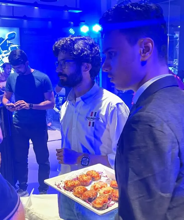 Our server offering appetizers to guests at the launch event for Shaman Triumph motorcycles. We ensure our staff is professional and attentive, providing seamless service at corporate functions.