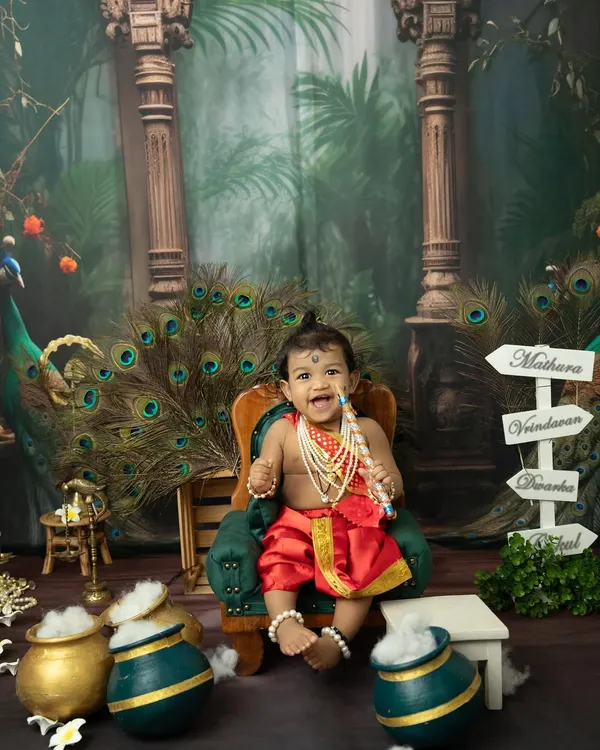 A joyful little Krishna sitting on his throne. Our Janmashtami mini sessions are filled with vibrant colors, peacock feathers, and playful props like pots of "butter".