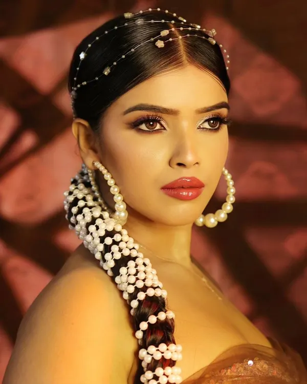 A stunning beauty close-up focusing on intricate hair styling with pearls and flawless makeup. This type of shot is perfect for showcasing the skills of both the photographer and the hair and makeup team.