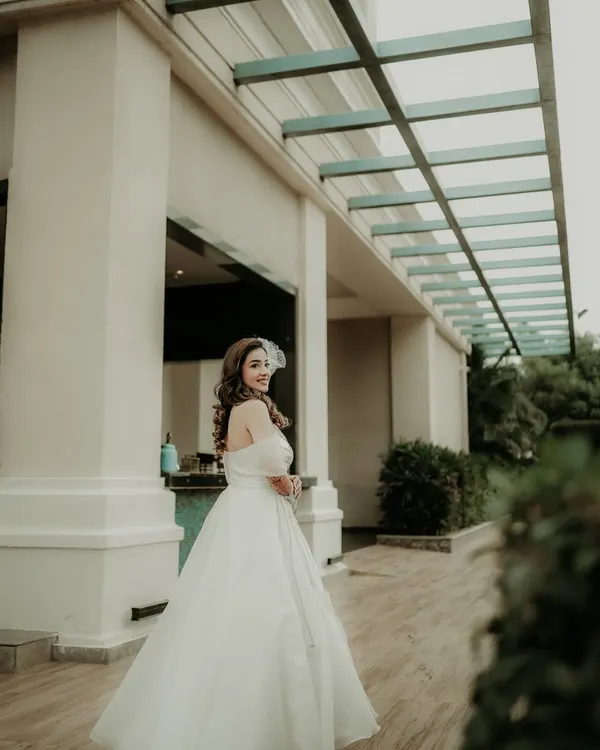 A beautiful glance over the shoulder. This portrait captures the bride in her stunning white gown, her happy expression and the elegant setting creating a timeless and graceful image.