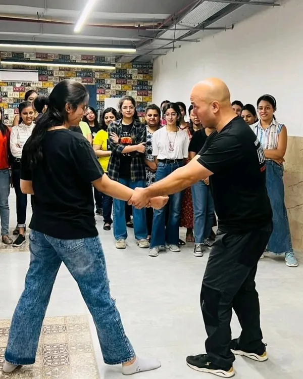 I demonstrate a wrist grab escape to a group of women during a corporate workshop. This is a foundational technique, showing how simple leverage can overcome a size disadvantage, a core principle of the Kavach system.