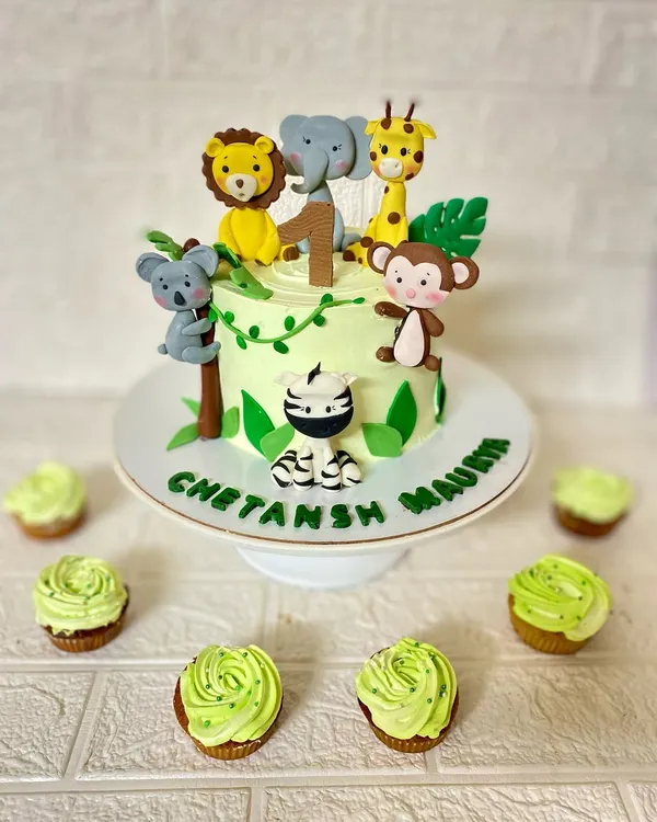 This jungle-themed cake is covered in our handmade fondant animals. We sculpted a friendly lion, elephant, giraffe, koala, monkey, and zebra to create a wild first birthday celebration.