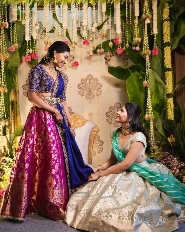 For our bride Sindhu's pellikuthuru ceremony, we designed a backdrop inspired by the grace of a peacock. The rich colors of her lehenga were complemented by a traditional setting fatores of floral garlands and banana leaves.