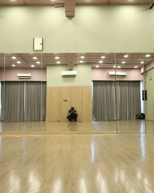Our versatile studio space is available for rent. This wide shot shows the full expanse of the floor, perfect for large group rehearsals.