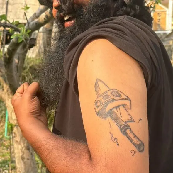 This custom tattoo, "Murder da Beats," was a collaboration for my homeboy, a music producer and chef. He gave me total freedom, so I combined his passions for beats and blades into this graffiti-style boombox and knife piece on his upper arm. This is what happens when you bring me your story.