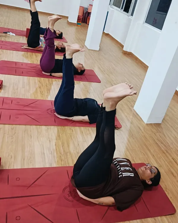 Students practicing Urdhva Prasarita Padasana (Upward Extended Feet Pose), an excellent asana for strengthening the core and lower abdominal muscles.